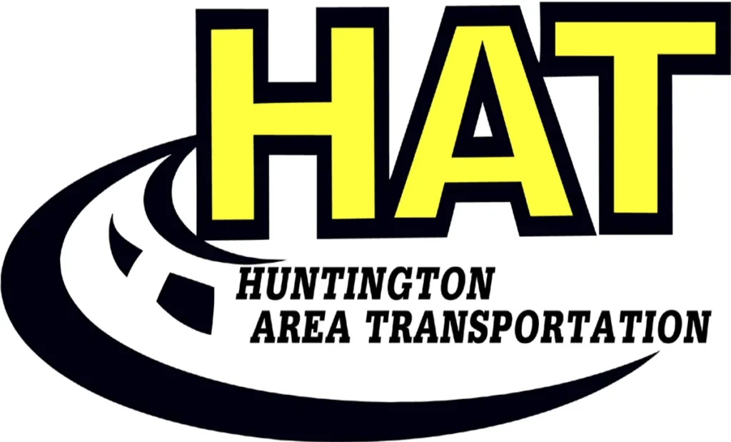 Logo of Huntington Area Transportation (HAT) featuring large yellow letters "HAT" above smaller black text "Huntington Area Transportation" with a stylized black and white road curving underneath.